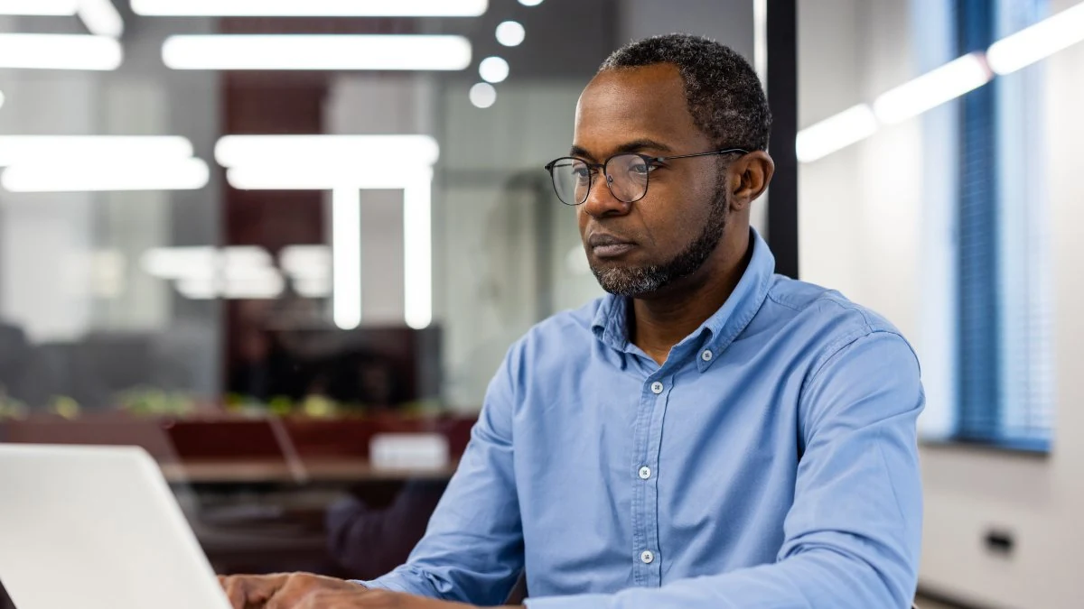 Financial advisor reviewing client details at his laptop