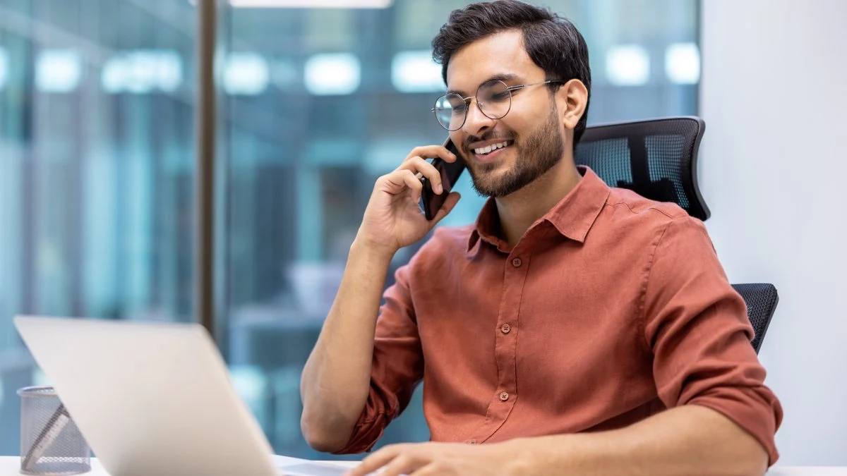 IT services rep on a client call at his laptop