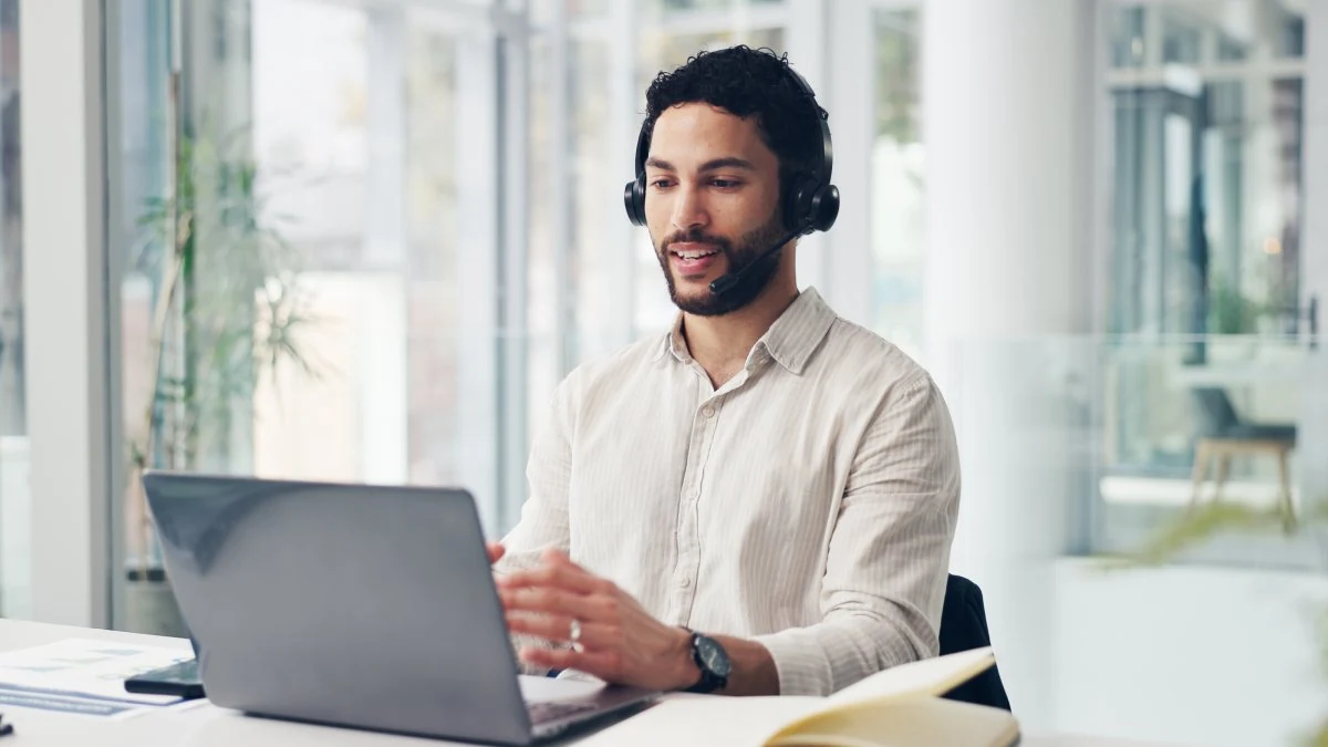 Technical sales rep on a headset call at his laptop