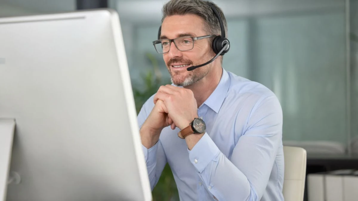 Senior account executive on a headset call, listening attentively at his computer