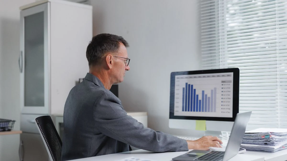 Sales leader reviewing a bar chart of results on his monitor