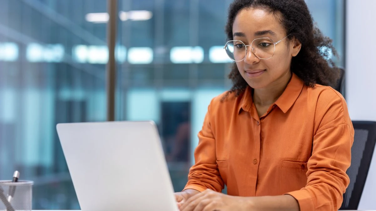 Sales rep working through coaching feedback at her laptop