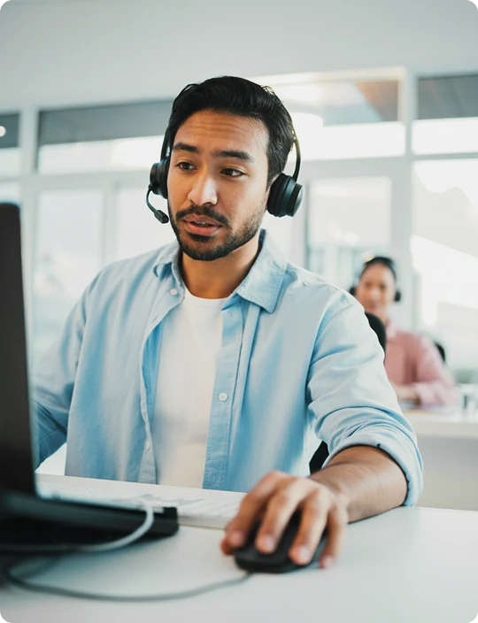 IT sales rep focused on a call at a monitor with a headset